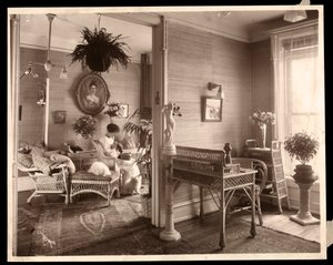 Een vrouw die naaiwerk doet in een zitkamer, 1914 of 1915